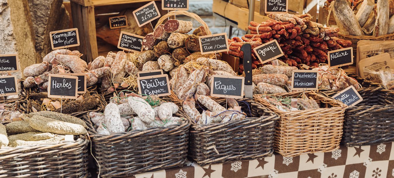 Open air market stand selling different kinds of salami - Annecy, France