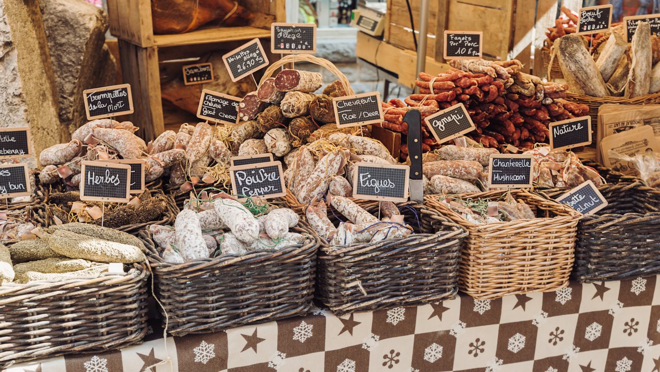 Open air market stand selling different kinds of salami - Annecy, France
